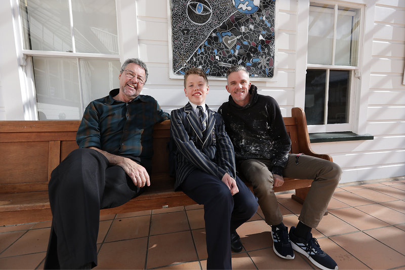 A Wellesley old boy from Wellington College sitting with his teachers, smiling