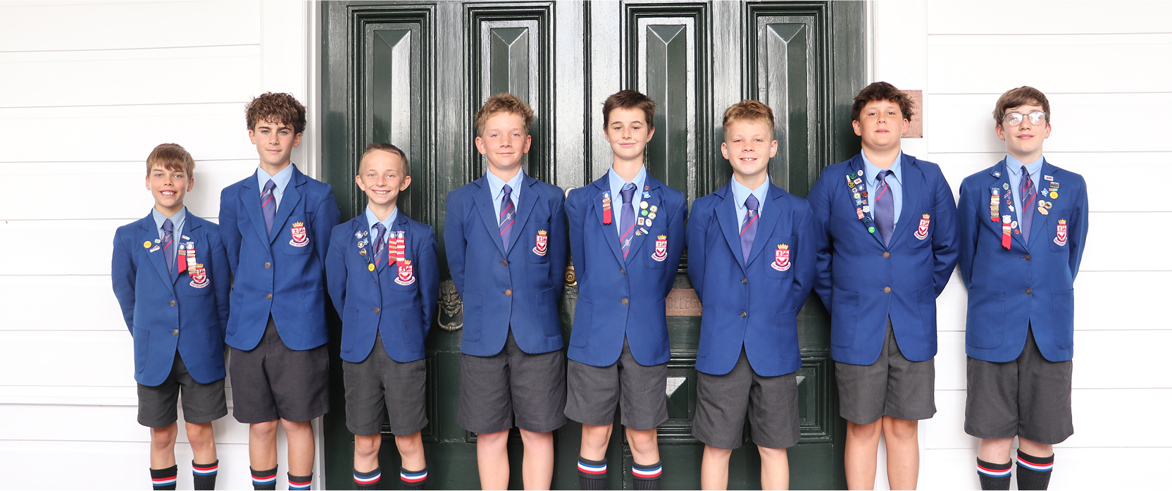 Wellesley College house captains standing together at Days Bay House, smiling for a group photo