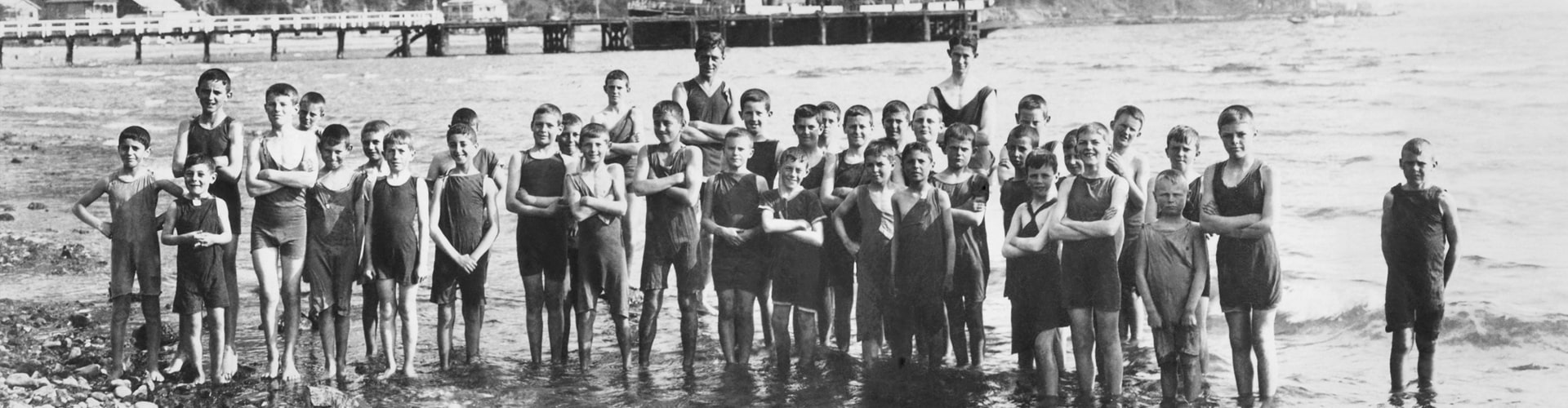 Black-and-white photo of boys at Days Bay, Wellington, standing together and smiling for the camera