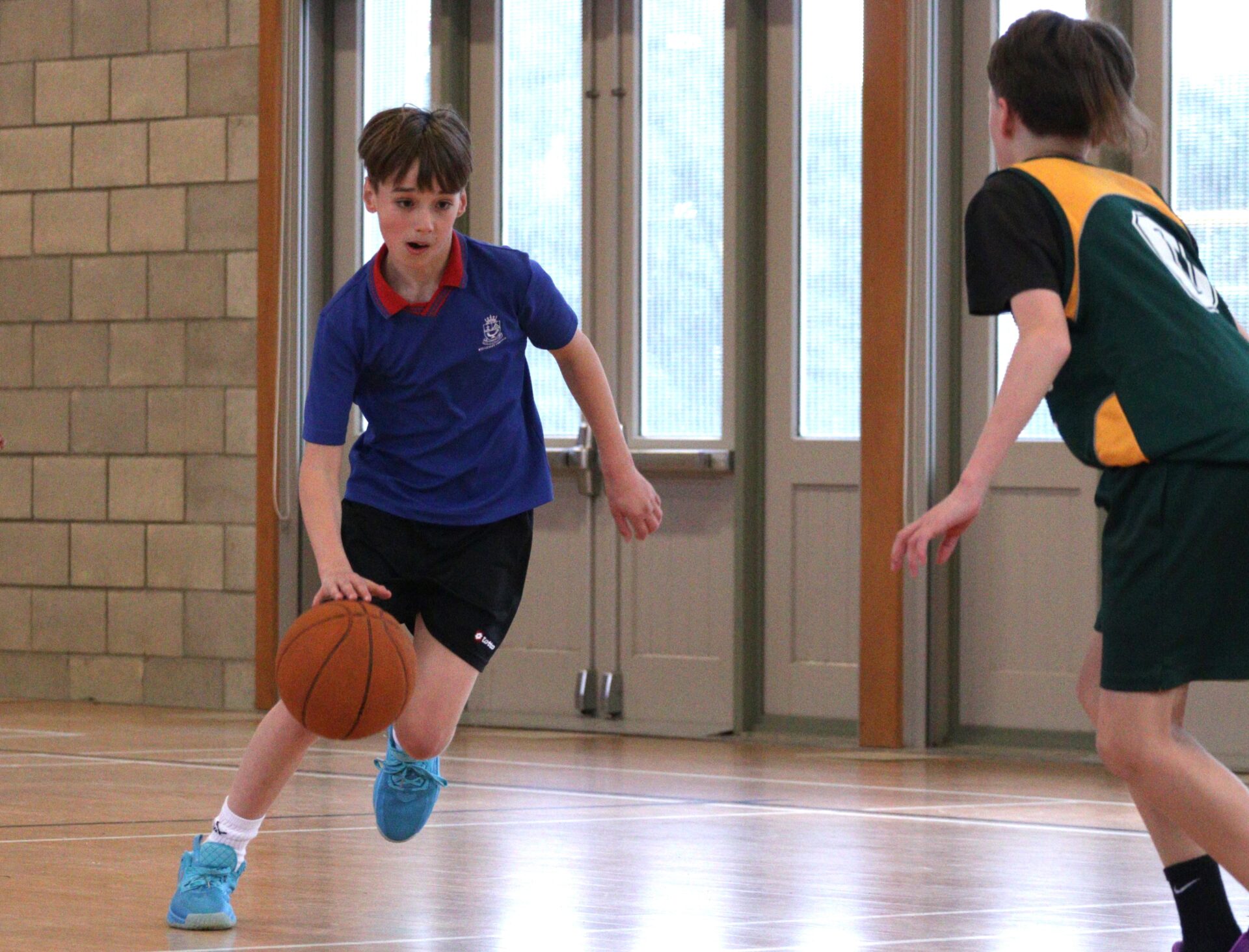Wellesley College students playing basketball in the school hall, actively engaged in the game