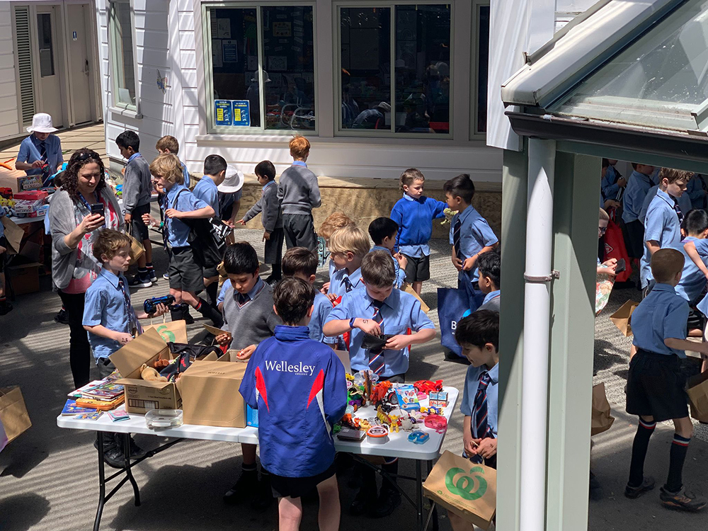 A group of school children browsing and interacting at a mini market