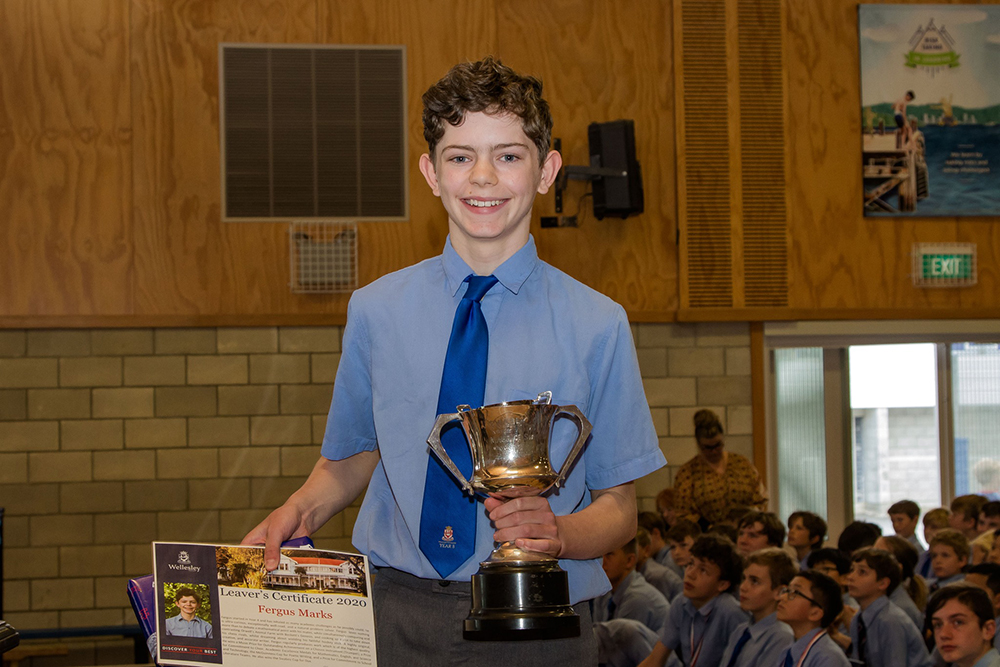 Fergus Marks holding a trophy and smiling at Wellesley College